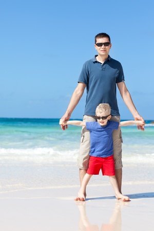 happy family of two spending time together at the perfect caribbean beachの写真素材