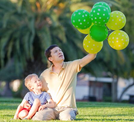 happy family of father and his son with colorful balloonsの写真素材