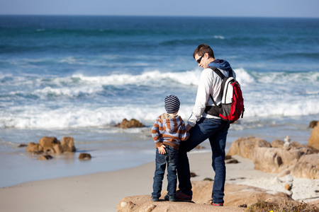 family of two spending time together by the ocean and enjoying the viewの写真素材