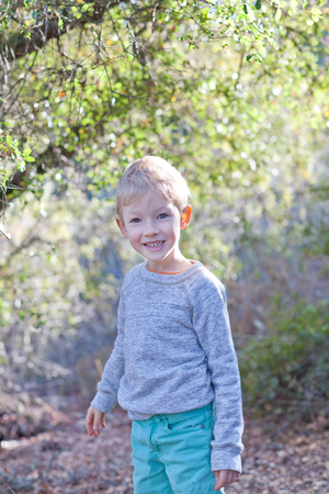 beautiful smiling boy enjoying spring during walk in the forestの写真素材