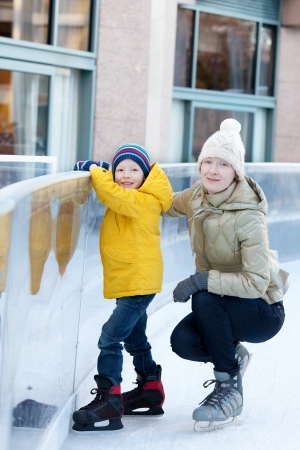 happy positive family of two ice skating at winterの写真素材