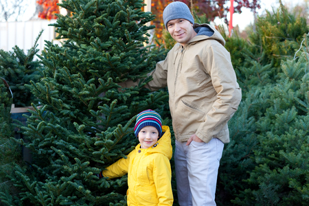 cheerful family of two buying christmas tree togetherの写真素材