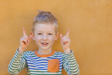 cute positive little boy showing his fingersの写真素材