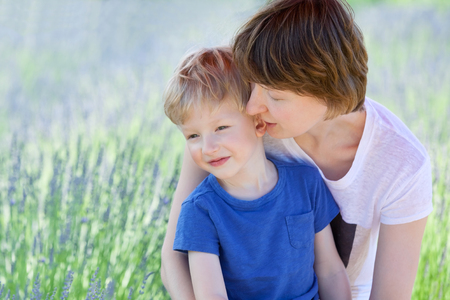 happy family of mother and son at blooming lavender fieldの写真素材