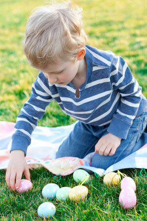 happy positive boy coloring easter eggsの写真素材