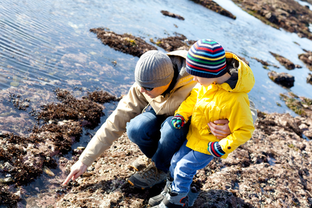 family of father and son enjoying tide pools togetherの写真素材