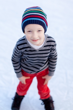 smiling positive boy ice skating at winterの写真素材