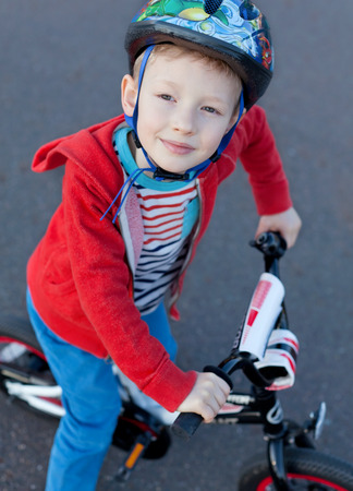 cute little boy riding the bike outsideの写真素材