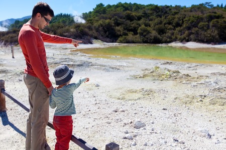 family of two looking at colorful hot spring at the north island in new zealandの写真素材