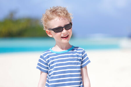 smiling little boy having fun at the beach during summer vacationの写真素材