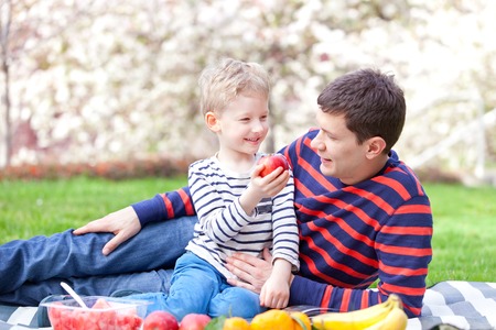 handsome young father and his son having fun together at the picnicの写真素材