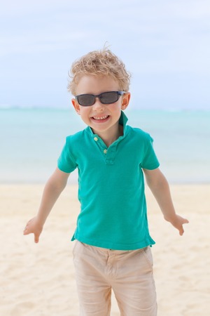 cheerful little boy having fun at the beachの写真素材