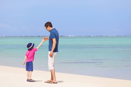 handsome father and his little son playing together at the tropical beachの写真素材