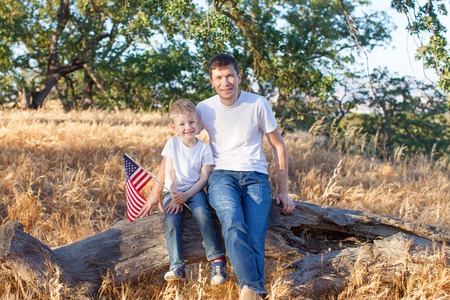 handsome father and his little son holding american flag celebrating 4th of Julyの写真素材