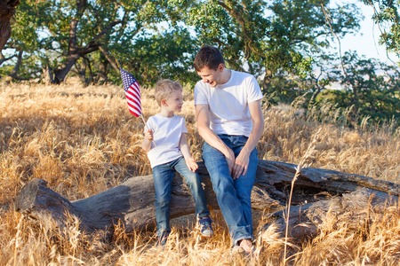 handsome father and his little son holding american flag celebrating 4th of Julyの写真素材