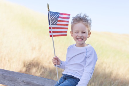 little boy holding american flag and celebrating 4th of Julyの写真素材