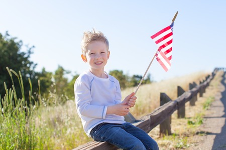 little boy holding american flag and celebrating 4th of Julyの写真素材