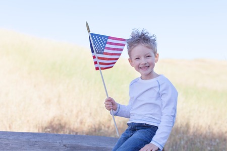 little boy holding american flag and celebrating 4th of Julyの写真素材