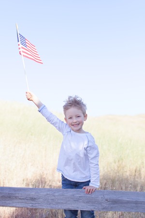 little boy holding american flag and celebrating 4th of Julyの写真素材