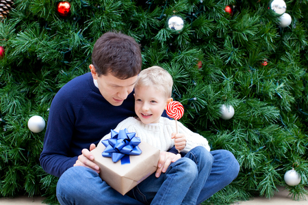 family of two enjoying christmas time by the tree with presentsの写真素材