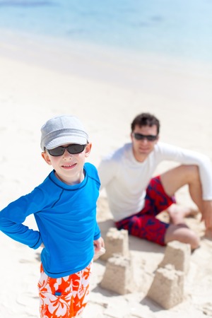 happy father and son building sand castle at the beachの写真素材
