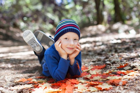 little kid enjoying autumn time at the parkの写真素材