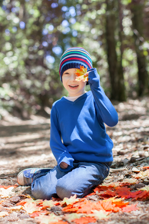 little kid enjoying autumn time at the parkの写真素材