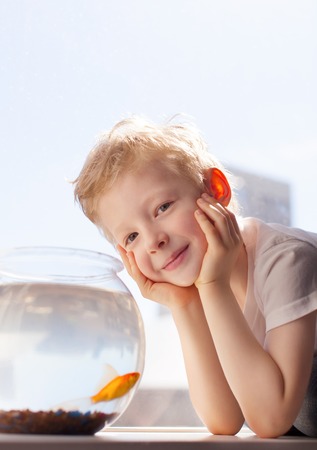 cute cheerful boy with goldfishの写真素材