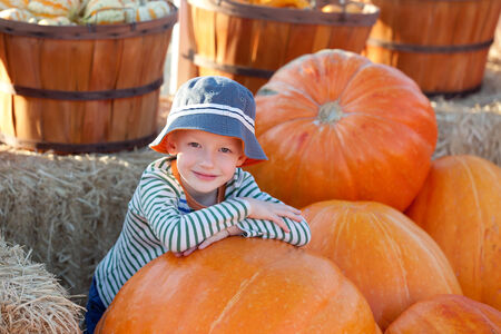 cheerful little boy at pumpkin patch, fall timeの写真素材