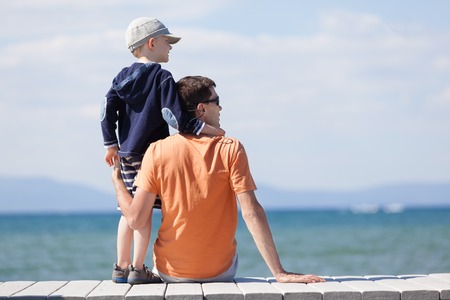 cheerful family of two sitting at the dock during vacation at lake tahoe, california, usaの写真素材