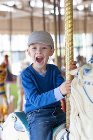 cheerful little boy having fun at the amusement parkの写真素材