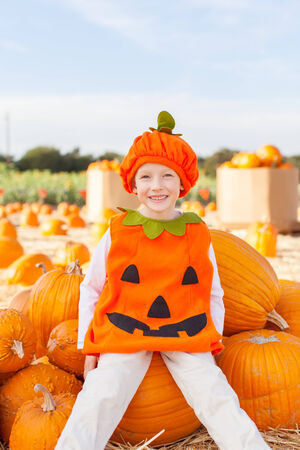 little smiling boy in pumpkin costume ready for halloweenの写真素材