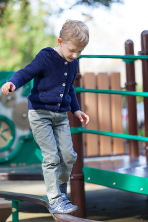 little boy balancing at the kids playgroundの写真素材