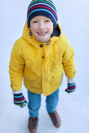 smiling little boy having fun at winter ice skatingの写真素材