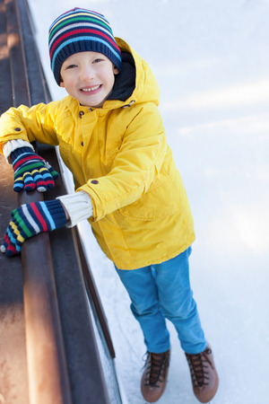 smiling little boy having fun at winter ice skatingの写真素材