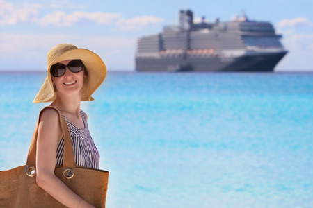 young woman enjoying time at the beach, cruise ship in the backgroundの写真素材