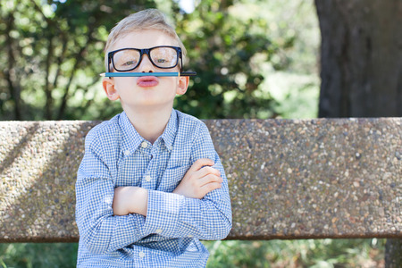 funny schoolboy in glasses being silly ready to go to school, back to school conceptの写真素材