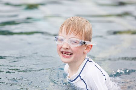 little boy having fun at the pool, vacation and happiness conceptの写真素材