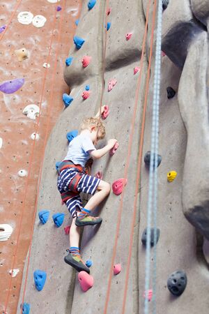 little boy climbing in indoor gymの写真素材