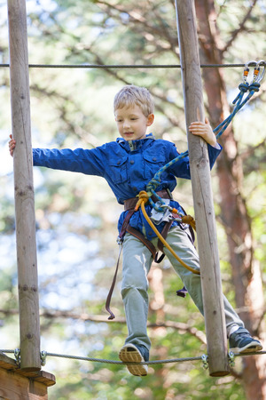 brave little boy enjoying treetop adventure parkの写真素材