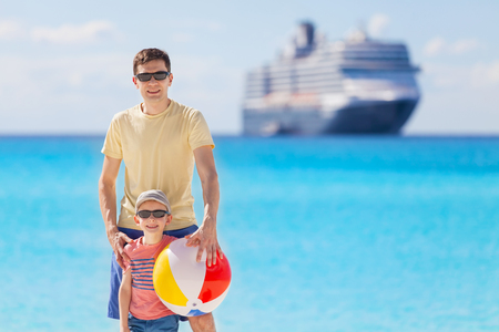 young father and his little son enjoying beach vacation and playing with beach ball, cruise and beach vacation conceptの写真素材