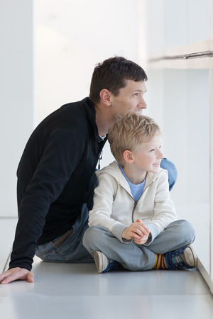 cheerful family of two sitting at the airportの写真素材