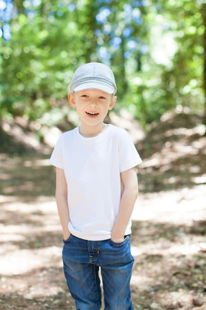 positive smiling boy feeling comfortable and relaxed walking in the forestの写真素材