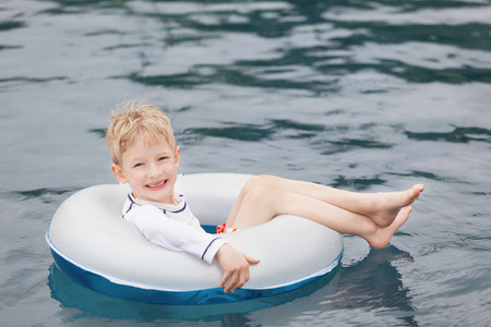 little boy enjoying swimming pool and vacationの写真素材