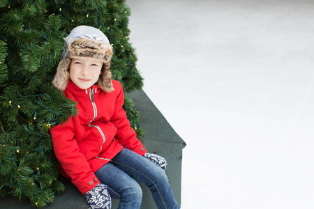 positive smiling boy enjoying winter vacation at outdoor ice skating rinkの写真素材