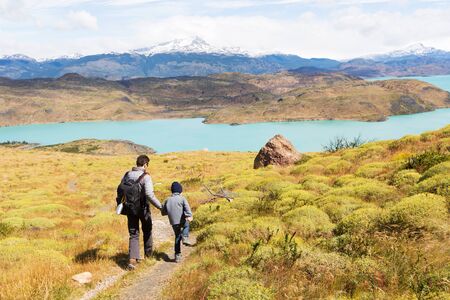 active father and his son having adventure hike at torres del paine national park, patagonia, chileの写真素材