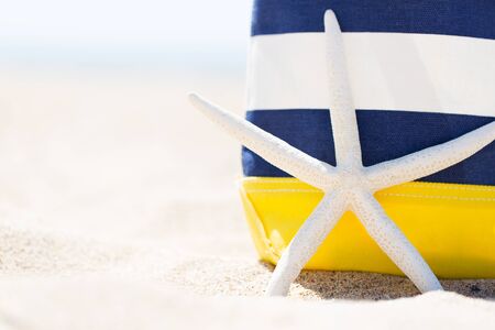 closeup picture of colorful beach bag and starfish at the beach, vacation conceptの写真素材