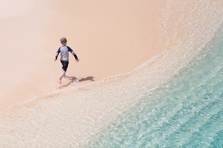 little boy running and enjoying summer vacation at perfect caribbean beach at anguilla, vacation conceptの写真素材