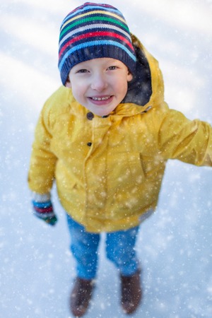 little boy enjoying winter time and ice skating at outdoor rink