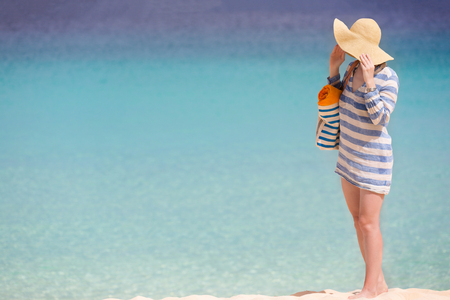 woman in sunhat and beach cover enjoying perfect caribbean beach, copyspace on sideの写真素材